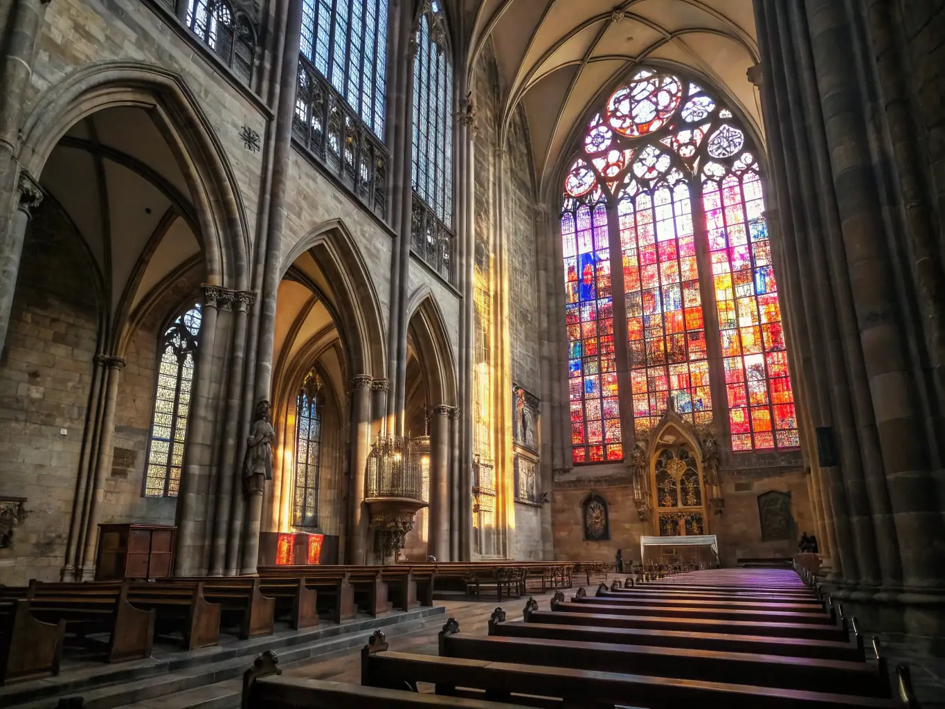 A photograph capturing a guided tour inside Senez Cathedral, focusing on a stained glass window with sunlight streaming through, highlighting the beauty and historical significance.